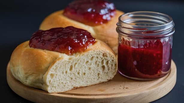 A close-up view of a freshly baked bread roll, cut open to reveal its soft, fluffy interior.
