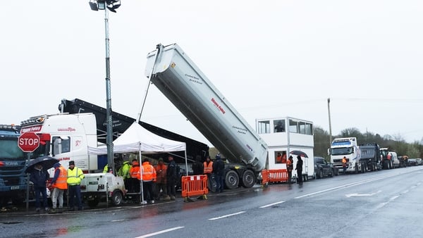 A large truck with its trailer raised parked at side of road
