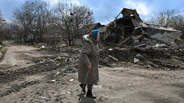 A local resident walks past a destroyed house following an air attack in Yasynuvata, Russia-controlled Donetsk region.