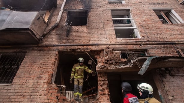 Firefighters work at a residential building destroyed by a Russian drone in the Ukrainian city of Sumy.