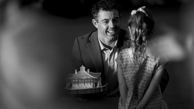 a black and white image shows rory mcilroy talking to his daughter