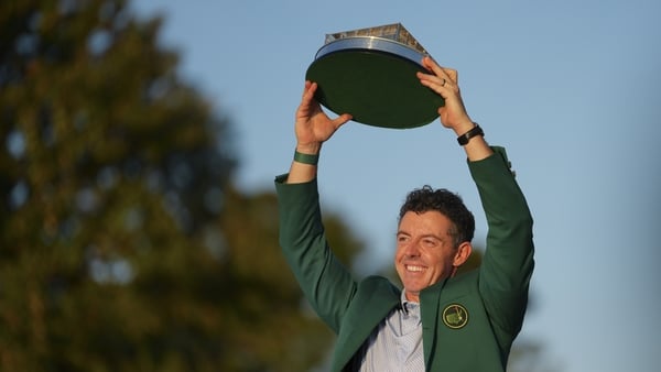 Rory McIlroy holds the trophy wearing his Green Jacket