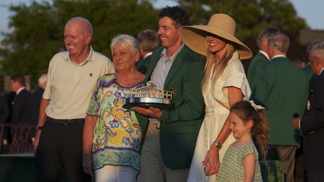 rory mcillroy holds the masters trophy as he stands with his parents, wife and daughter