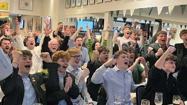 people cheer and raise their arms in the air in celebration