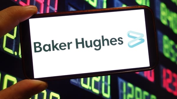 Image of a mobile phone screen with Baker Hughes signage against a financial screen background