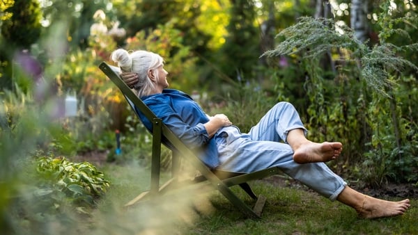 Mature woman relaxing in deckchair in her garden