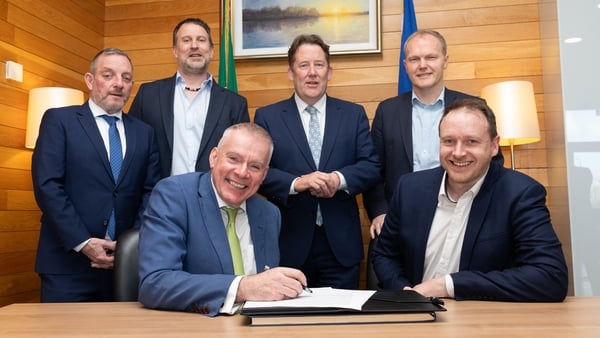 Group of business men and politicians in suits around a table to sign a deal
