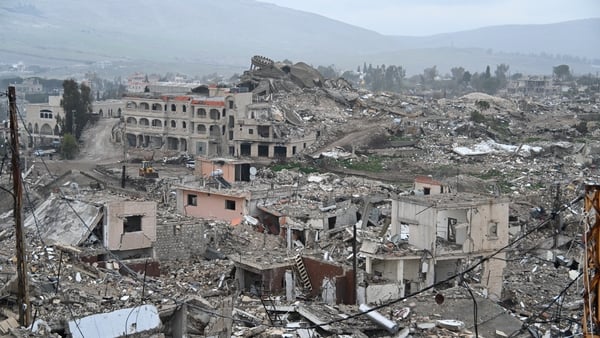 Wide image shows destroyed buildings and debris.