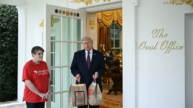US President Donald Trump holds McDonald's bags outside the Oval Office at the White House