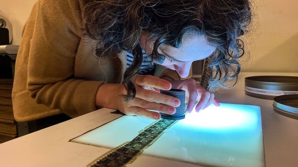 Nitrate Film vault technician Courtney Holschuh using a viewing loupe, views the actual film of Georges Méliès's 1897 French short silent film Gugusse et l'Automate at the Nitrate Film vault at the Packard Campus of the Library of Congress's National Audio-Visual Conservation Center in Culpeper, Vir