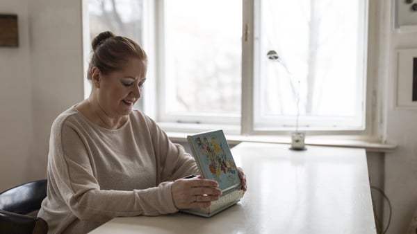 Image of senior woman looking in jewellery box at home