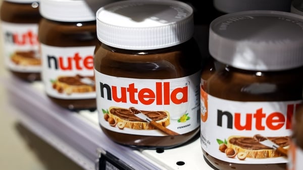 Close up image of four jars of Nutella chocolate spread on a shelf at a supermarket.