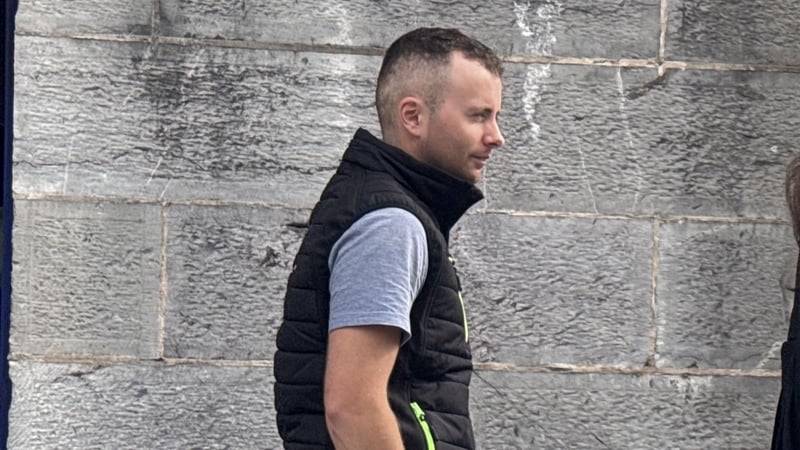 Profile head and shoulders image shows a man in his 20s wearing a light coloured tshirt and a dark coloured jacket against a stone wall background.
