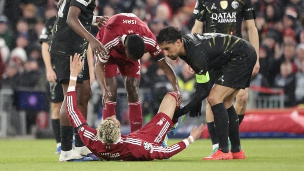 LIVERPOOL, ENGLAND - APRIL 14: Hugo Ekitike of Liverpool - suffering from an achilles tendon injury - is helped by Willian Pacho of PSG, Alexander Isak of Liverpool, Marquinhos of PSG during the UEFA Champions League 2025/26 Quarter-Final Second Leg match