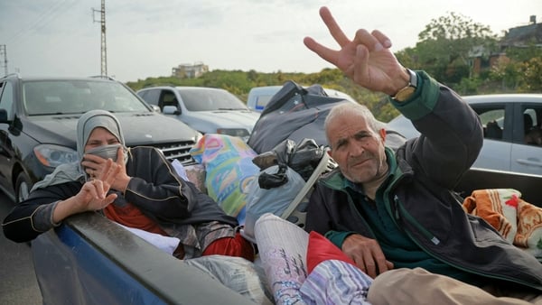 A displaced resident travels through the Qasmieh area as he flashes a victory sign on the way back to his home in southern Lebanon