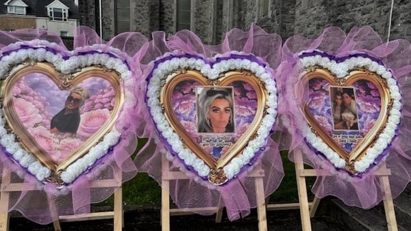 Pink floral arrangements outside the church with pictures of Scarlett Faulkner