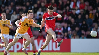 Paul Cassidy of Derry shoots at goal under pressure from John Morgan of Antrim - 2026 Ulster SFC
