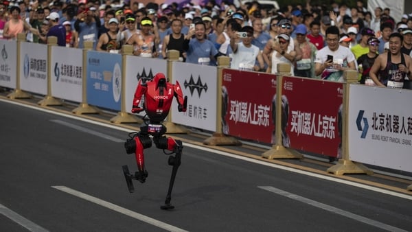 An Honor H1 humanoid robot runs during a half-marathon race