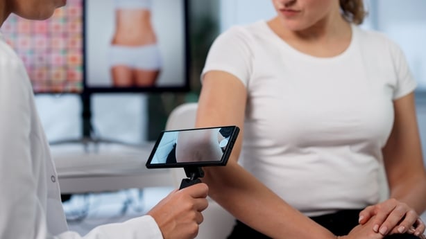 Dermatologist Uses Computer Technology To Diagnose Skin Conditions On Woman