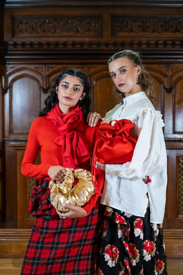 Two models holding handbags by August Night