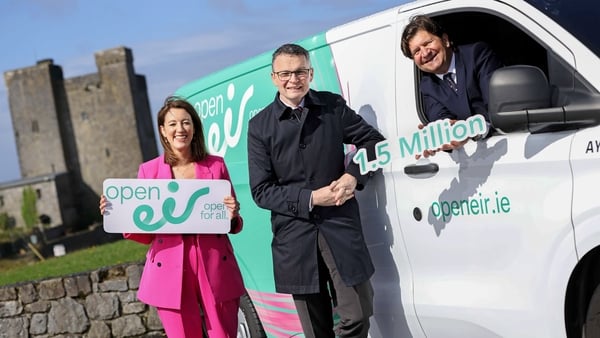 One woman and two men pose with an Open eir van and signage