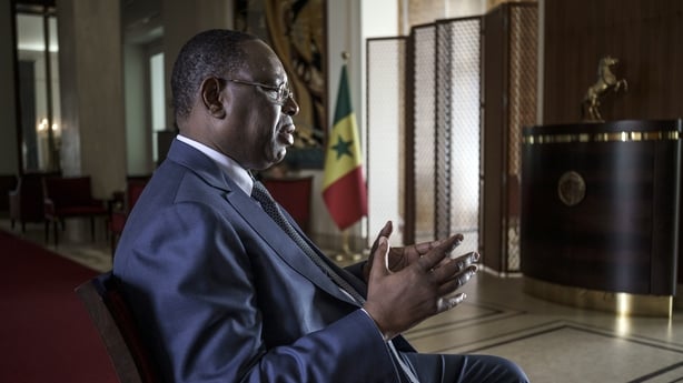 Macky Sall, Senegal's president, sitting in profile in a chair with his hands gesturing