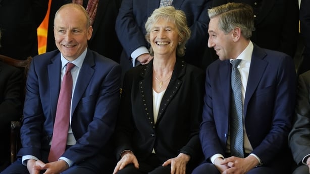 President of Ireland Catherine Connolly chats with Taoiseach Michael Martin and Tánaiste Simon Harris at Áras an Uachtaráin