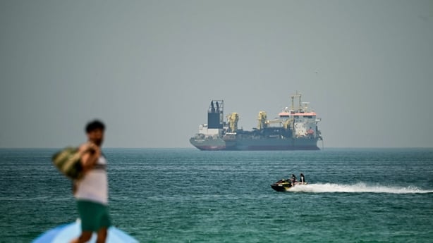 A commercial vessel is seen off the coast of Dubai on April 20, 2026. Oil prices jumped sharply on April 20 over fears hostilities could resume in the weeks-long war, after Iran closed the Strait of Hormuz again over the weekend following its brief reopening on Friday in recognition of a ceasefire i