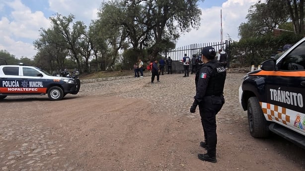 police officers and police cars stand at the entrance to an archaeological site in mexico