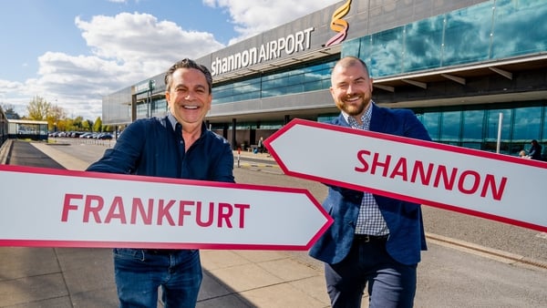 Two men pose with signs at Shannon Airport for the launch of a new route to Frankfurt