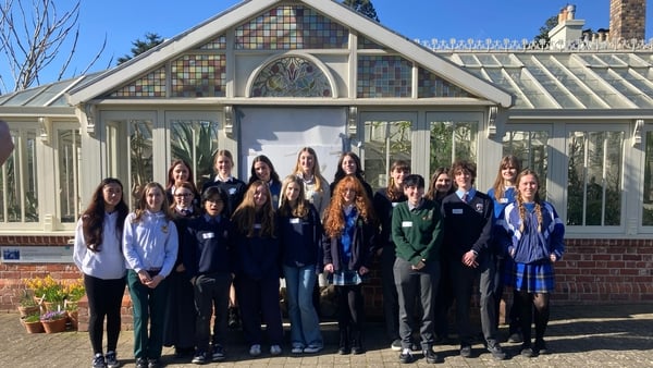 A group of Irish Schools Sustainability Network ambassadors pose in front of a glasshouse at the Botanic Gardens in Dublin.