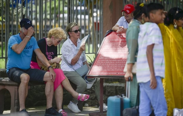 Tourists fan themselves in high temperatures