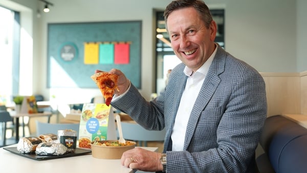 Image of a business man eating a slice of pizza in a service station