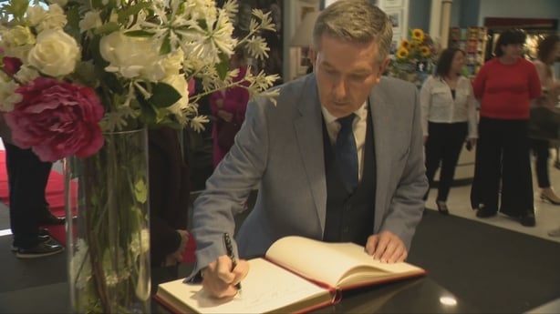 Daniel O'Donnell signs a visitor book at an exhibition celebrating his work
