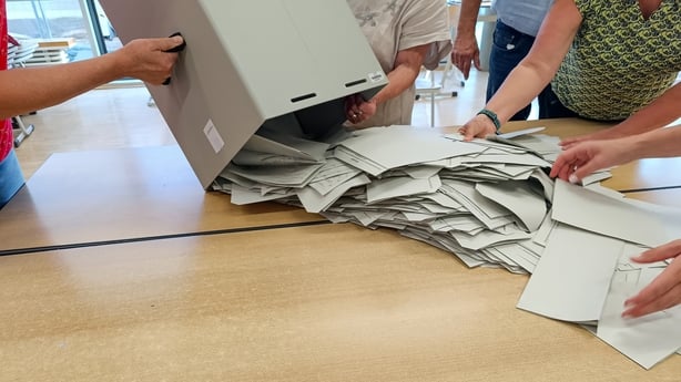 Ballot papers being spilled from a box onto a table