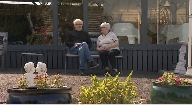 Two people sit outside