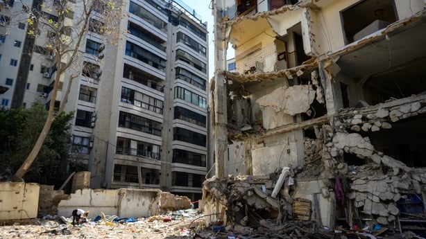 BEIRUT, LEBANON - APRIL 23: A woman collects debris from a building in ruins in the Ain al-Mreisseh neighborhood after Israeli airstrikes on April 8 struck 100 targets in 10 minutes across the country, on April 23, 2026 in Beirut, Lebanon. Roughly halfway through 10-day ceasefire, Lebanese and Israe