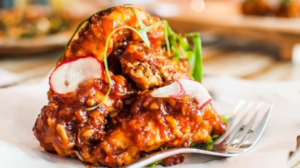 A close-up view of deep fried chicken wings with barbecue sauce on the table