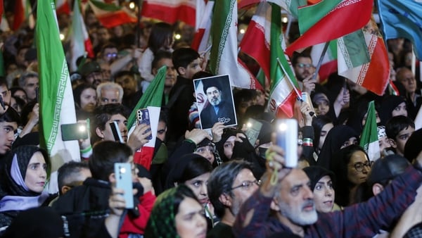 People carrying Iranian flags gathered in Revolution Square to protest against the United States and Israel in Tehran.