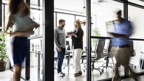 Business colleagues looking at digital tablet in modern conference room - motion blur