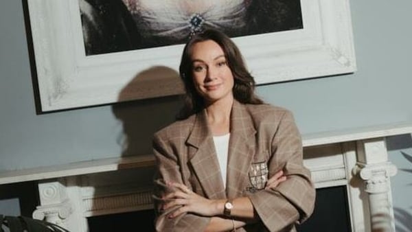 Image of a business woman posing in front of a fireplace