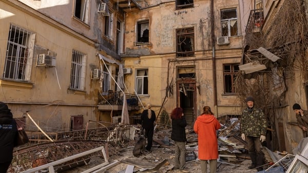 People stand amid debris in the yard of damaged residential building after Russian drone attack on April 27, 2026 in Odesa, Ukraine. As of this morning, 11 people have been injured, including 2 children. All are receiving necessary medical care. Cars, res