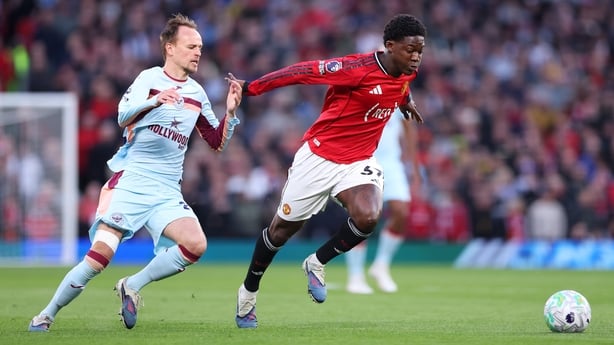 Kobbie Mainoo of Manchester United is challenged by Mikkel Damsgaard of Brentford during the Premier League match between Manchester United and Brentford at Old Trafford on April 27, 2026 in Manchester, England.