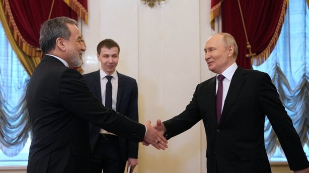 Russian President Vladimir Putin shakes hands with Iranian Foreign Minister Abbas Araghchi 