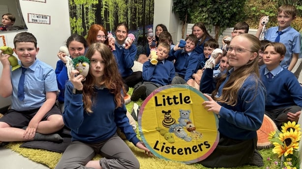 Pupils from Lissenhall National School in Co Tipperary are pictured with toys and sitting around a sign which says 'Little Listeners'