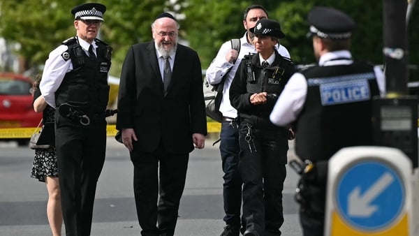 etropolitan Police Commissioner Mark Rowley (L) walks with Chief Rabbi Ephraim Mirvis (2R) as they visit the scene on Golders Green Road