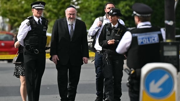 etropolitan Police Commissioner Mark Rowley (L) walks with Chief Rabbi Ephraim Mirvis (2R) as they visit the scene on Golders Green Road