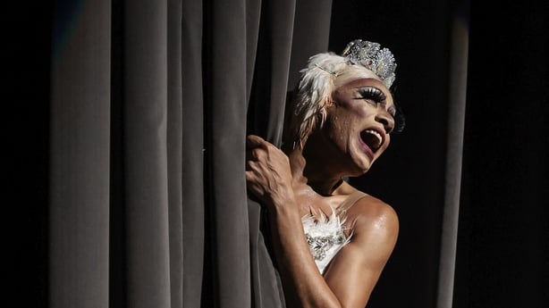 A dancer entering stage from behind a curtain