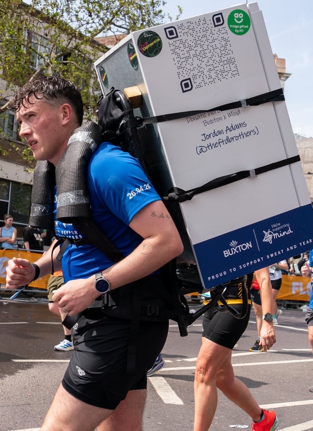 Jordan Adams is seen running the London Marathon with a 25kg fridge on his back to raise awareness for dementia as part of his personal challenge to take on 32 marathons in 32 days. (Photo by Bonnie Britain/SOPA Images/LightRocket via Getty Images)