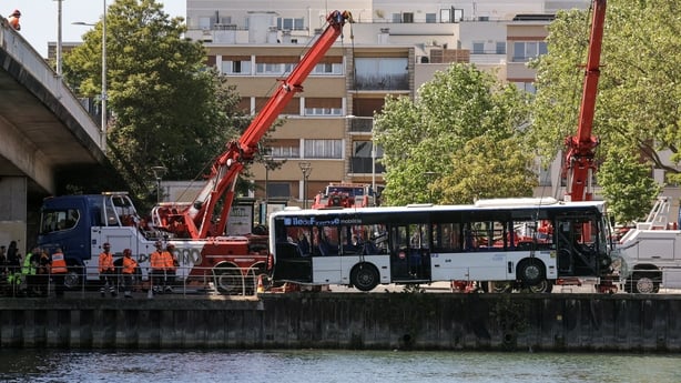 Towing teams remove a bus from the Seine river